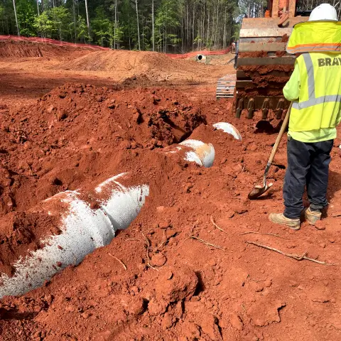 Properly installed erosion control barriers and stormwater management infrastructure ensuring environmental regulatory compliance for a local development.